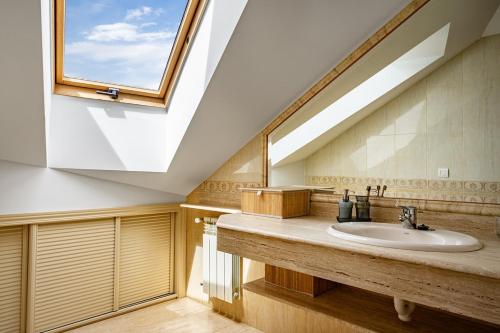 a bathroom with a sink and a skylight at Trail House in Pola de Lena