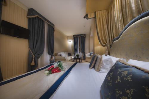a hotel room with two beds and a large window at Hotel A La Commedia in Venice