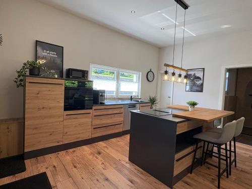 a kitchen with a counter and a kitchen island with a microwave at Ferienhaus Lenz in Kalenborn