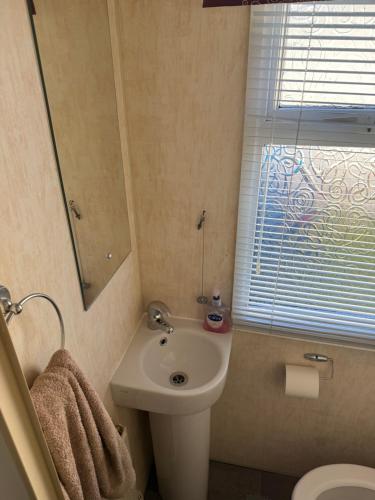 a small bathroom with a sink and a toilet at Jemmas Holiday Home in Arbroath