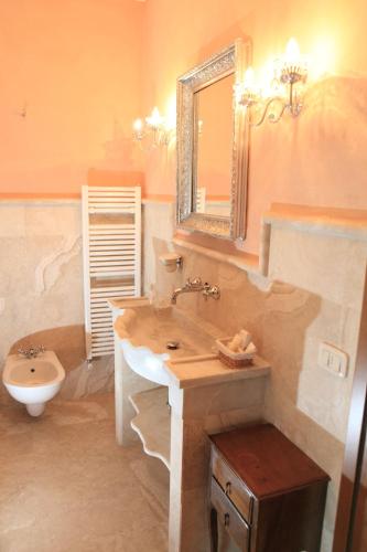 a bathroom with a sink and a toilet and a mirror at Agriturismo Il Raduno - Max Lelli in Marsiliana