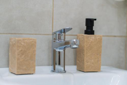 a bathroom sink with a faucet and two paper towels at Il Cortile della Patrona in Syracuse