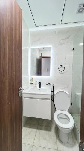a white bathroom with a toilet and a sink at Jawharat Tetouan in Souani