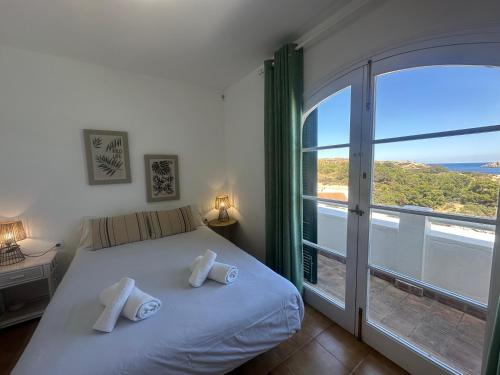 a bedroom with a bed and a large window at White Sands 3.08 in Arenal d'en Castell