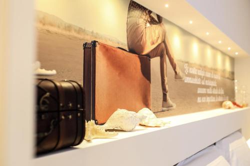 a shelf with a suitcase and a picture of a woman at F53 Kevin's Charming Houses in Alghero