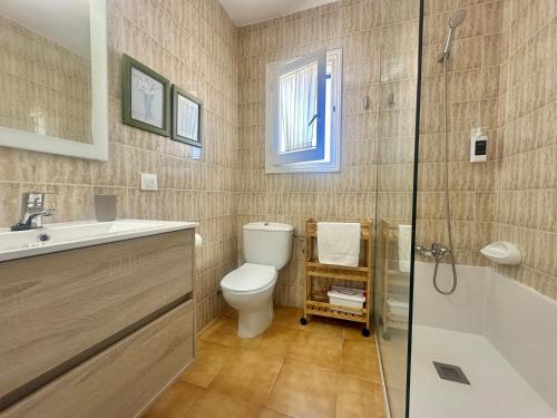 a bathroom with a toilet and a sink and a shower at White Sands 3.08 in Arenal d'en Castell