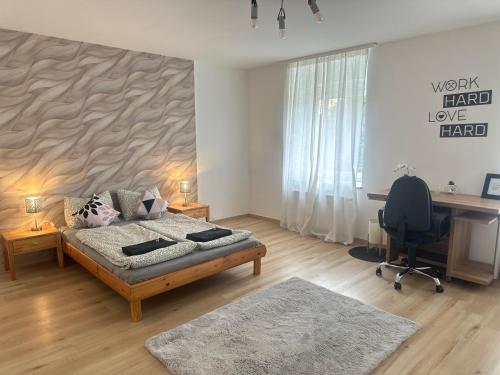 a bedroom with a bed and a desk with a computer at Shine Home in Klagenfurt