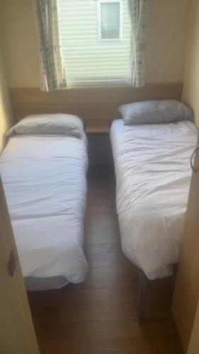 two beds in a small room with a window at The Colorado van in Rhyl