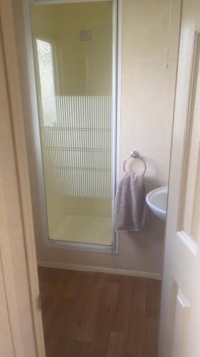 a bathroom with a glass shower and a sink at The Colorado van in Rhyl
