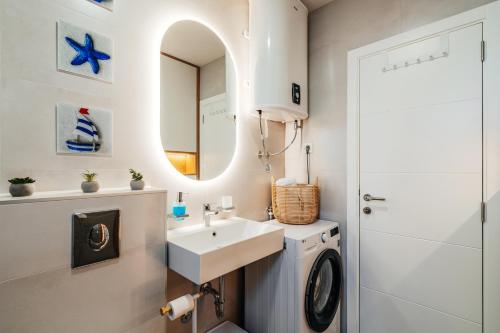 a bathroom with a sink and a washing machine at Maria Premium BELLA VISTA in Baošići