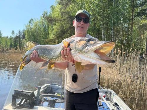 a man holding a large fish in his hand at Villa Norppa in Punkaharju