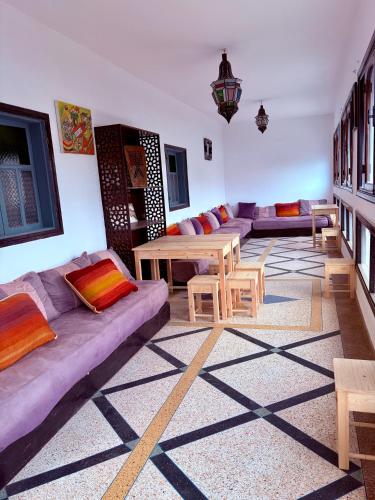 a living room with couches and tables in a room at Hôtel grand Atlas in Mirleft