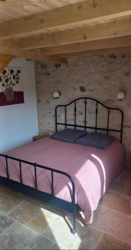 a bed in a room with a wooden ceiling at Gite des Egadillias climatisé in Marsanne
