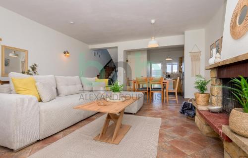 a living room with a white couch and a table at Casa Cyra in Alexandroupoli