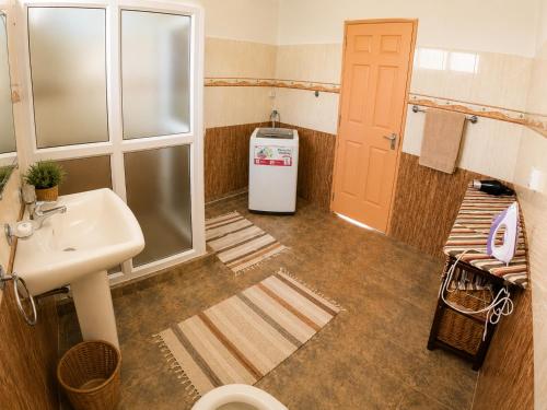 a bathroom with a sink and a washer and dryer at Suntoo Villa Wind & Kitesurf Accommodation in La Gaulette
