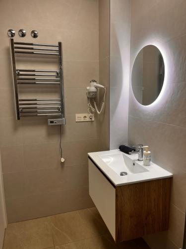 a bathroom with a sink and a mirror at Roque Home Stay in La Mata