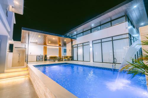 a swimming pool with a waterfall in a house at Amethyst Bcd in Bacolod