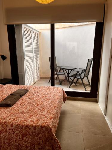 a bedroom with a bed and a table and chairs at Roque Home Stay in La Mata
