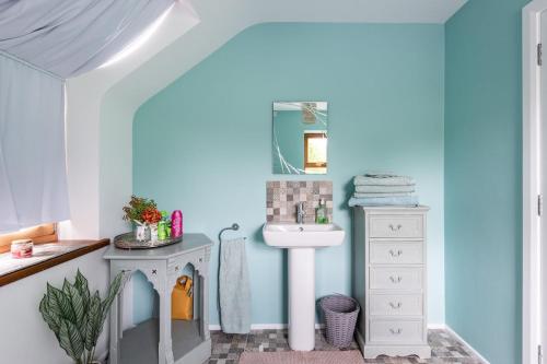 a bathroom with a white sink and a mirror at Corlea Studio in Dunwish