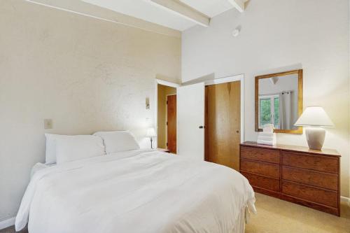 a white bedroom with a large bed and a window at Seasons 307 in Warren