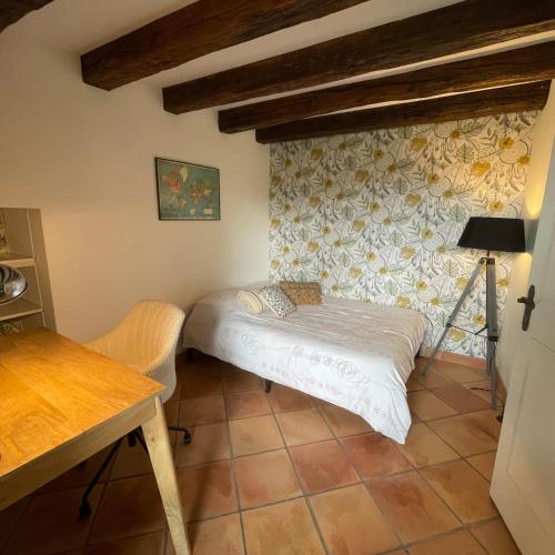 a small room with a bed and a wall with flowers at Villa avec piscine in Soyaux