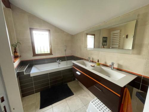 a bathroom with a tub and a sink and a bath tub at Villa avec piscine in Soyaux