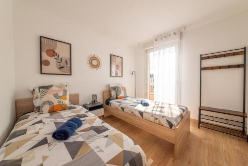 a bedroom with two beds and a window at Warm cocoon - parking included in Asnières-sur-Seine