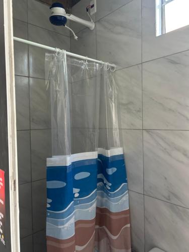 a shower curtain is hanging in a bathroom at Pousada das Redes in João Pessoa