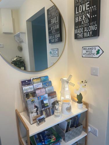 a mirror on a wall above a shelf with products at Atlantic way Apartment in Sligo