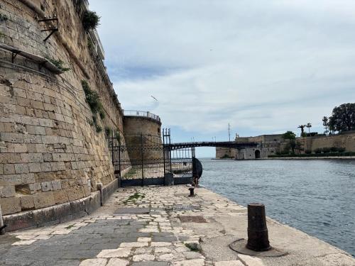 a person standing next to a wall next to a river at Acqua Holiday House in Taranto