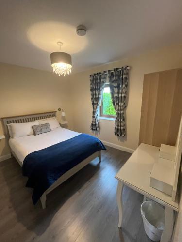 a bedroom with a bed and a table and a window at Atlantic way Apartment in Sligo