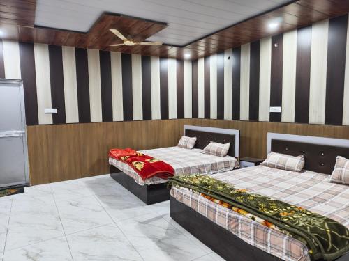 two beds in a room with striped walls at Madan Usha Resort in Chitrakoot