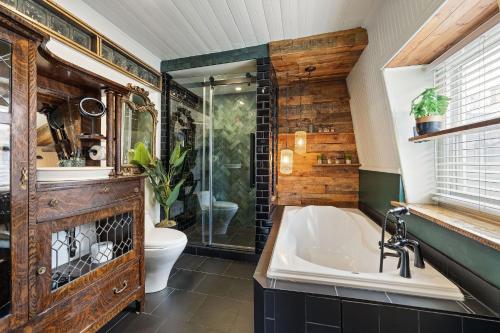 a bathroom with a tub and a shower and a toilet at Le Ricochet Urbain in Quebec City