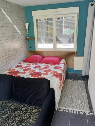 a bedroom with a bed and a window and a couch at Chez Isa in Saint-Martin-Boulogne