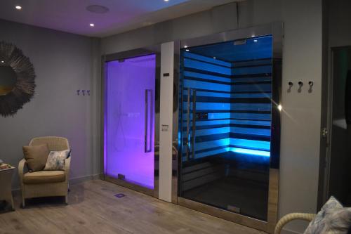 a room with a glass shower with purple lighting at Fishmore Hall Hotel and Boutique Spa in Ludlow