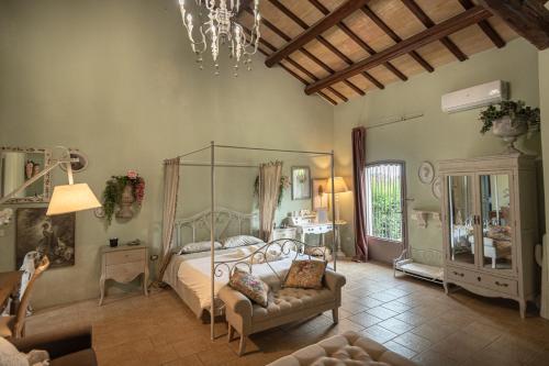 a bedroom with a bed and a couch and a chandelier at Il Borgo delle Pampare in Campello sul Clitunno