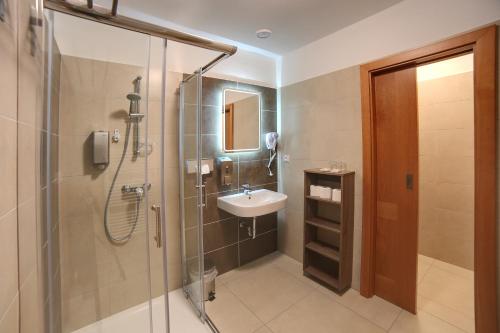 a bathroom with a sink and a shower with a sink at Golf&Wellness Resort Alfrédov in Alfrédov