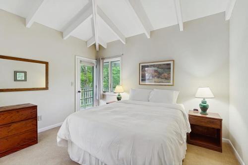a white bedroom with a large bed and windows at Seasons 308 in Warren