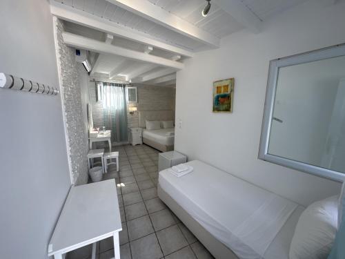 a small white room with a bed and a window at Casa Bianca in Ornos
