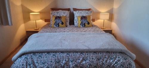 a bedroom with a large bed with two lamps at Gîte La petite maison 2 ch bain nordique privé Skadi & sauna in Les Fontenelles