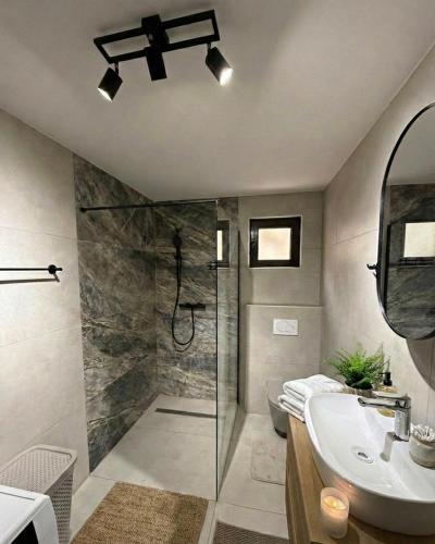 a bathroom with a shower and a sink at Cozy Apartment with Balcony in Ivanjica