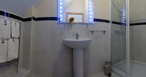 a bathroom with a sink and a shower at Glenmore House in Ballycastle