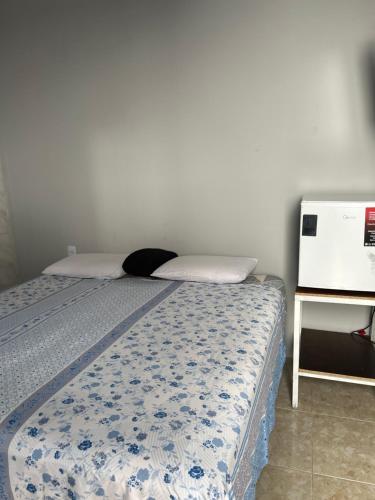 a bedroom with a bed with a blue and white comforter at Pousada das Redes in João Pessoa