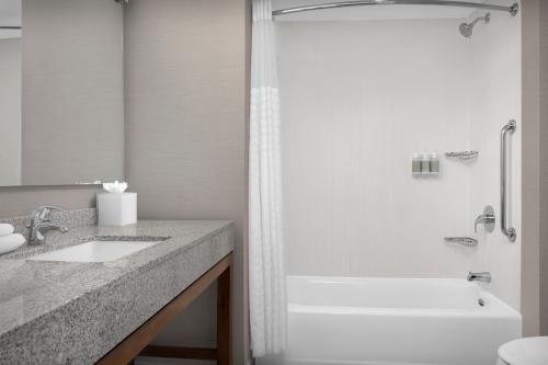 a bathroom with a tub and a sink and a shower at Courtyard by Marriott Richmond Downtown in Richmond