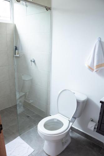 a bathroom with a toilet and a glass shower at Komfort House Premium in Medellín