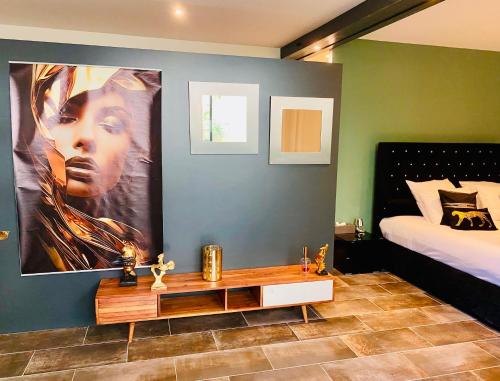 a bedroom with a bed and a large painting on the wall at Une Parenthèse in Barbentane