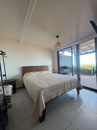 a bedroom with a bed and a large window at ALMAR House in Guaquen
