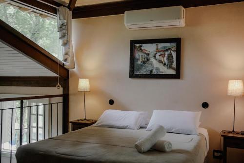 a bedroom with a bed with a fan on the wall at Villa Don in Petrópolis
