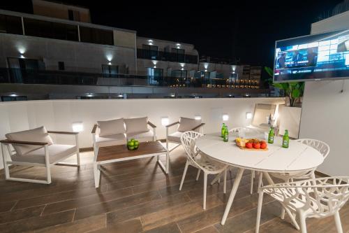 a dining room with a white table and chairs at MUNDOBOOKING Centro Levante in Benidorm