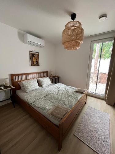a bedroom with a bed and a large window at Ala'Toboz Siófok in Siófok